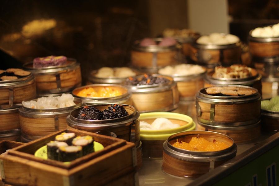 En un mostrador se exponen diversos platos dim sum en vaporeras de bambú, mostrando una variedad de alimentos asiáticos tradicionales coloridos y bien ordenados.